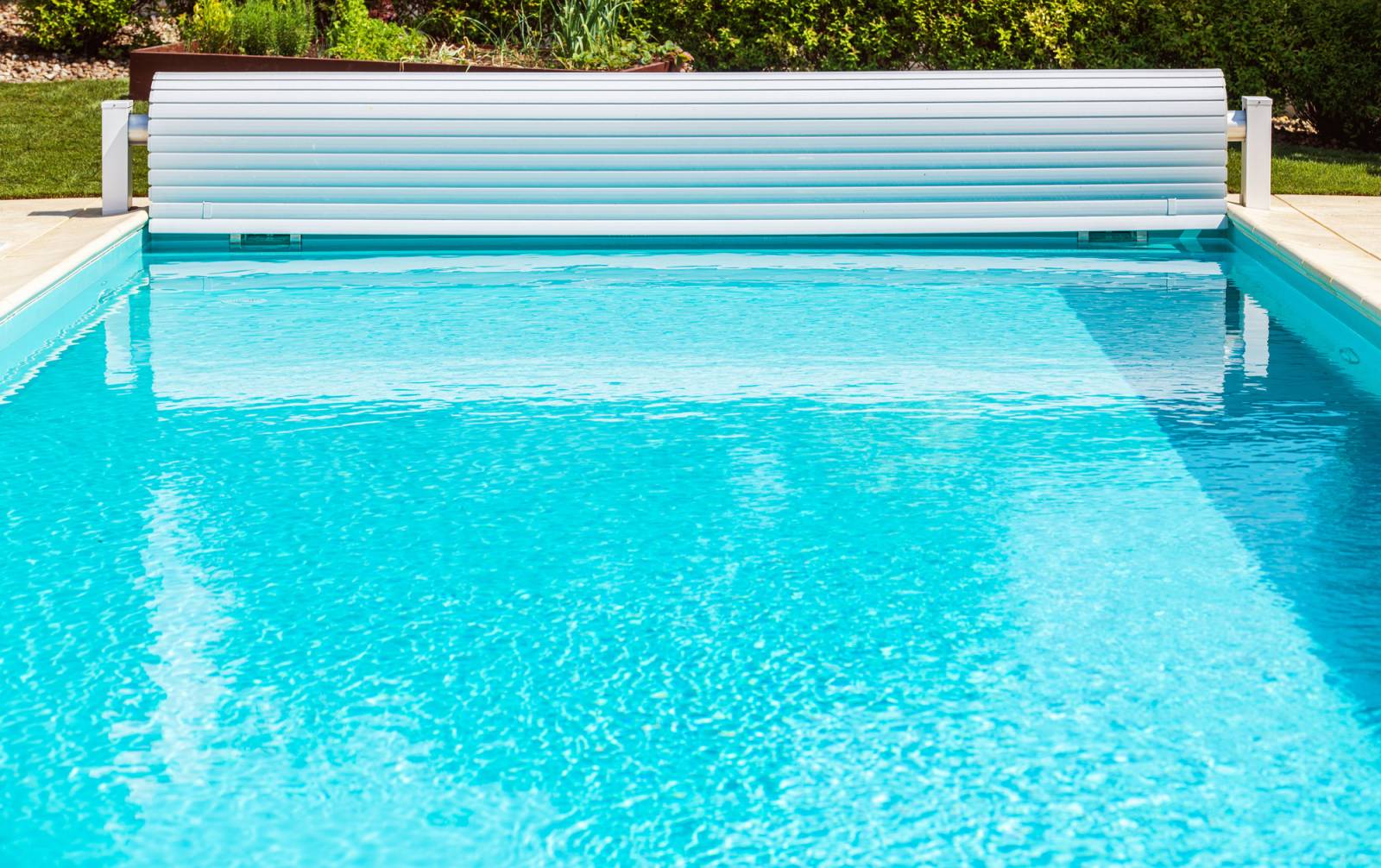 Piscine traditionnelle en béton avec volet roulant